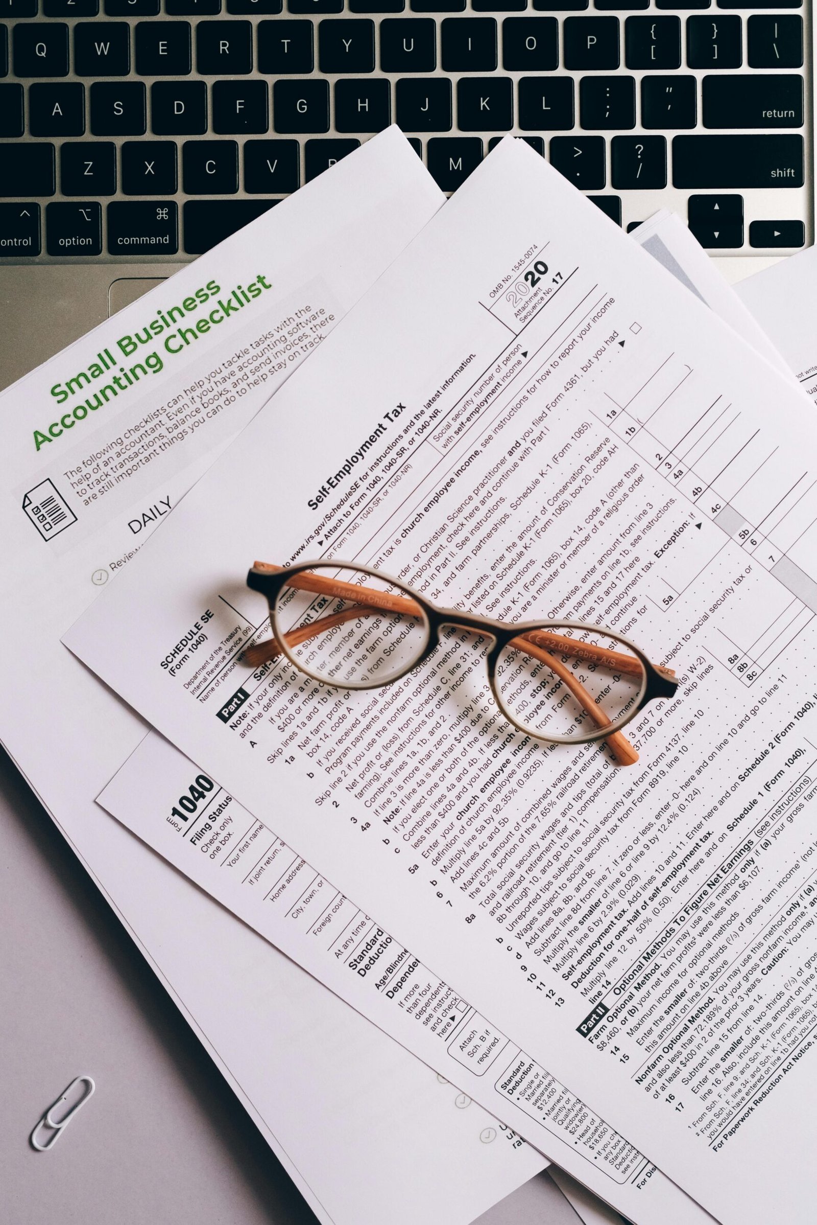 Formulario fiscal con gafas sobre documentos financieros impresos.